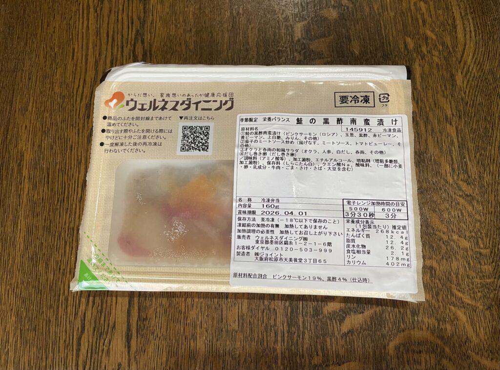 個包装された冷凍宅配弁当のパッケージ。温めてそのまま食べられる仕様で、メニューや栄養成分の表示も確認できる。