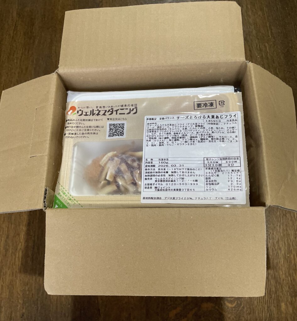 段ボール箱に梱包された宅配食が届いた様子。冷凍された食事が丁寧に収められており、配達直後の状態を写した写真。