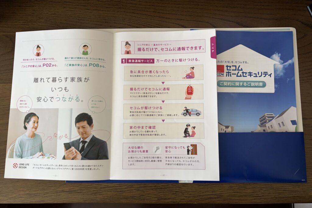 セコムから届いた資料の写真。救急通報サービスの流れが載った冊子と、契約に関するご説明書
